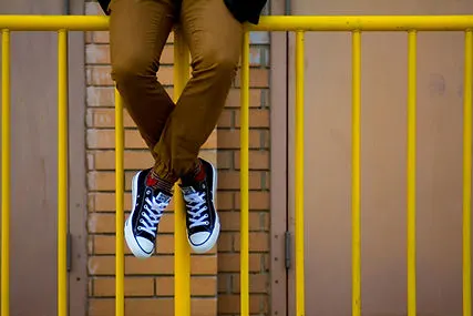 Person Sitting on Gate